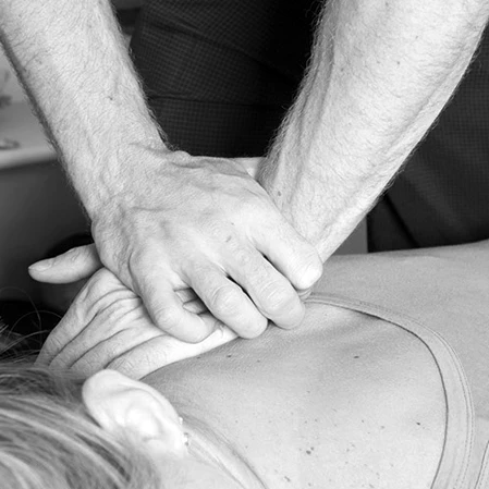 A chiropractic adjustment or spinal manipulation is being performed on a woman