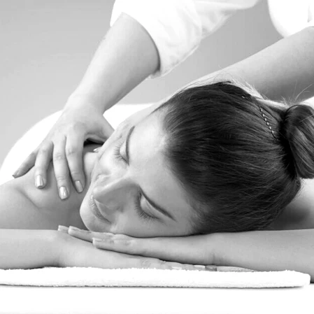 A woman is receiving massage therapy while resting peacefully